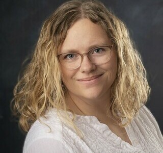 woman with long wavy blonde hair smiling for the camera