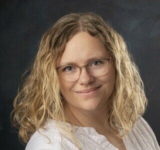 woman with long wavy blonde hair smiling for the camera