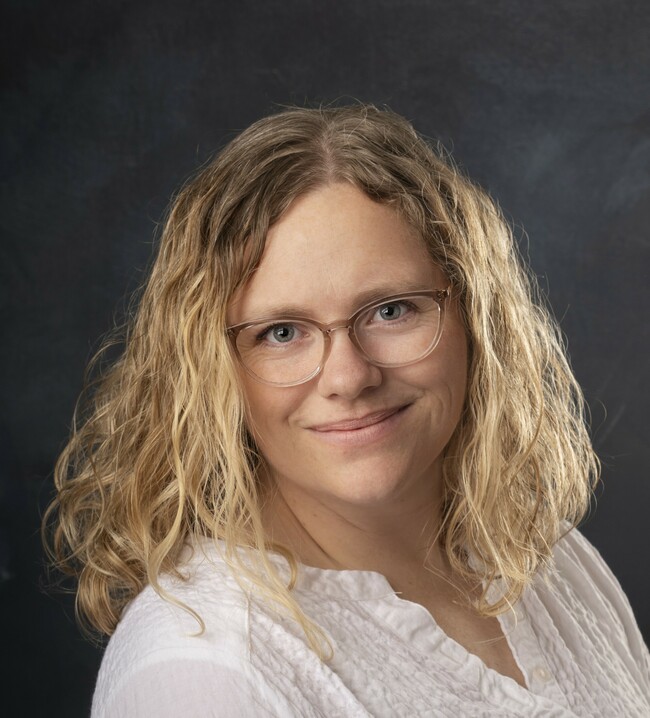 woman with long wavy blonde hair smiling for the camera